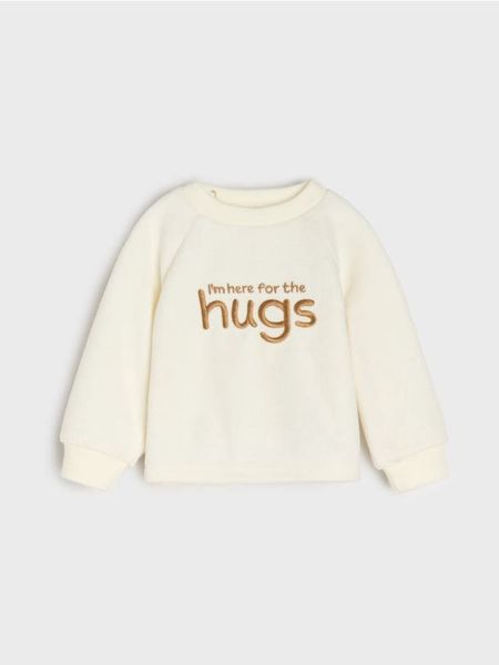 Welurowa bluza z haftowanym napisem - kremowy. Białe bluzy i bluzki niemowlęce Sinsay, bez wzorów, z weluru, bez ramiączek, bez kaptura. Za 15.99 zł.