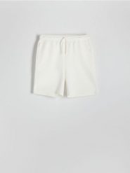 Dresowe szorty regular fit - złamana biel. Szorty męskie Reserved, z bawełny, bez kołnierzyka. W wyprzedaży za 55.99 zł.