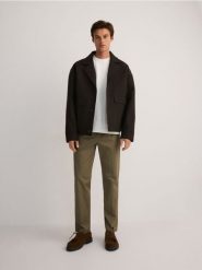 Bawełniane spodnie chino leisure fit - oliwkowy. Zielone spodnie materiałowe męskie Reserved, bez wzorów, z bawełny. W wyprzedaży za 49.99 zł.