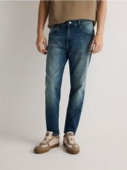 Jeansy carrot slim z efektem sprania - indigo jeans. Niebieskie jeansy męskie Reserved. W wyprzedaży za 79.99 zł.