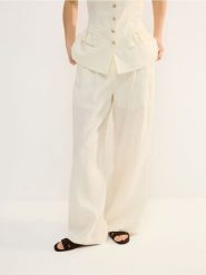 Lniane spodnie - złamana biel. Spodnie materiałowe damskie Reserved, bez wzorów, z tkaniny. Za 239.99 zł.