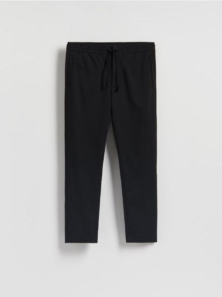 Spodnie joggery - czarny. Czarne spodnie materiałowe męskie Reserved, bez wzorów, z tkaniny. Za 139.99 zł.