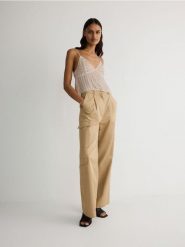 Spodnie wide leg - beżowy. Brązowe spodnie materiałowe damskie Reserved, bez wzorów, z bawełny. W wyprzedaży za 69.99 zł.