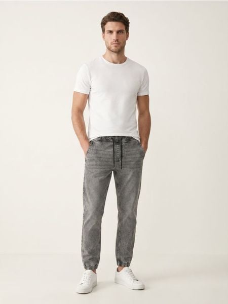 Jeansy jogger slim z efektem sprania - szary. Szare jeansy męskie Sinsay. Za 59.99 zł.