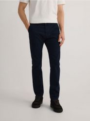 Bawełniane spodnie chino slim - granatowy. Niebieskie spodnie materiałowe męskie Reserved, bez wzorów, z bawełny. W wyprzedaży za 79.99 zł.