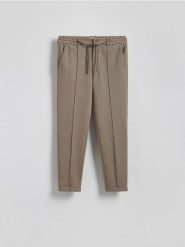 Spodnie chino slim - beżowy. Brązowe spodnie materiałowe męskie Reserved, bez wzorów, z bawełny. W wyprzedaży za 99.99 zł.
