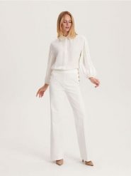 Spodnie z ozdobnymi guzikami - biały. Białe spodnie materiałowe damskie Reserved, bez wzorów, z bawełny. W wyprzedaży za 35.99 zł.