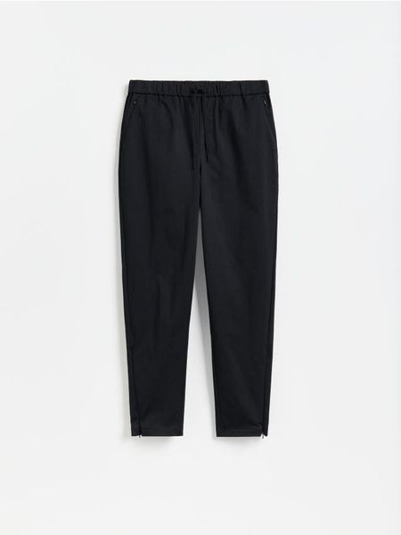 Spodnie slim carrot - czarny. Czarne spodnie materiałowe męskie Reserved, bez wzorów, z bawełny. Za 139.99 zł.