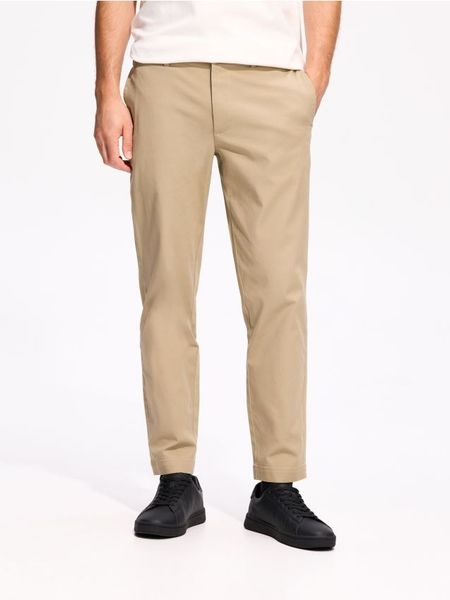Spodnie carrot fit - beżowy. Brązowe spodnie materiałowe męskie Reserved, bez wzorów, z bawełny. Za 149.99 zł.