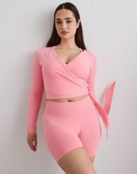 Damski top bezszwowy, kopertowy, z regulowanymi wiązaniami Shape różowy blush. Brązowe topy sportowe damskie Aim'n, m, bez wzorów, z dzianiny, bez ramiączek. Za 259.00 zł.