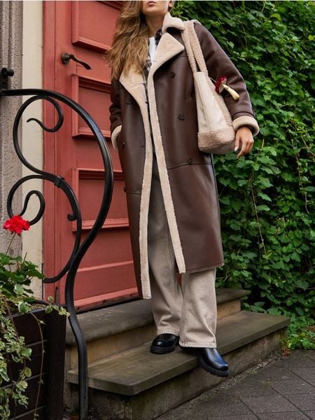 Długi płaszcz z imitacji skóry - brązowy. Brązowe płaszcze damskie Sinsay, l, bez wzorów, ze skóry. W wyprzedaży za 99.99 zł.