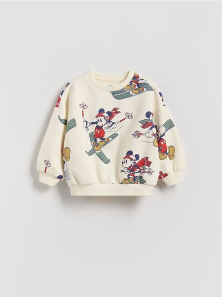 Bluza Mickey Mouse - złamana biel. Bluzy i bluzki niemowlęce Reserved, bez wzorów, z bawełny, bez ramiączek, bez kaptura. W wyprzedaży za 32.99 zł.