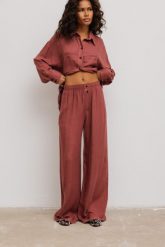 Spodnie z szerokimi nogawkami w kolorze LIGHT BURGUNDY- NASS-XS/S. Czerwone spodnie materiałowe damskie Marsala, bez wzorów, z gumy. Za 299.90 zł.